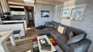 a living room with a couch and a kitchen at Hausboot Fehmarn in Fehmarn