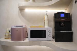 a microwave sitting on a shelf next to a coffee maker at Hotel Azure Incheon in Incheon