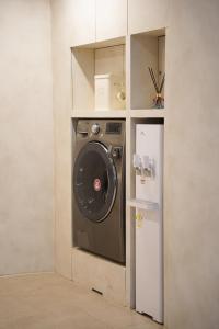 a kitchen with a washing machine and a refrigerator at Hotel Azure Incheon in Incheon