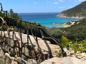 a bench sitting on top of a hill overlooking the ocean at Villa Sardinia Seaview&SPApool in Villasimius