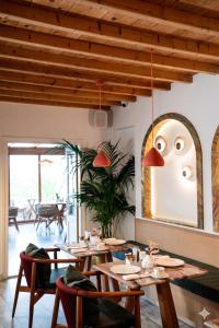 a restaurant with wooden tables and chairs and a large mirror at San Antonio Summerland in Mikonos