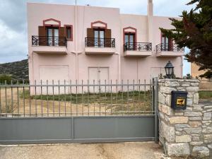 a pink house with a fence in front of it at Sergio's homes in Mélanes