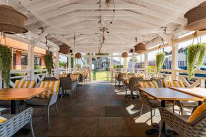 an empty restaurant with wooden tables and chairs at Hotel Kahlberg in Krynica Morska