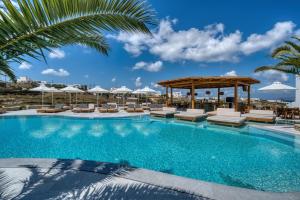 a swimming pool with lounge chairs and umbrellas at San Antonio Summerland in Mikonos