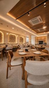 a dining room with wooden tables and chairs at Kaloka City Hotel Bima in Bima