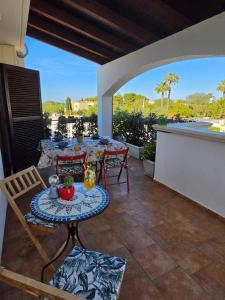 a patio with a table and chairs on a balcony at Villa Puglia AR 700m from beach -max 4 people- in Bisceglie