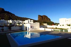 a swimming pool in front of a white building at Casa Lola in Agaete