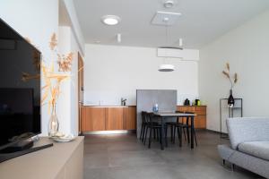 a living room with a table and a couch at Villa Mer, Bardot - Luxury apartment in Badhuis with swimming pool and sauna near the beach in Cadzand