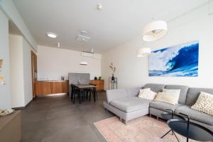a living room with a couch and a table at Villa Mer, Bardot - Luxury apartment in Badhuis with swimming pool and sauna near the beach in Cadzand