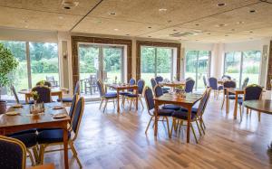 a dining room with tables and chairs and windows at Best Western Ipswich Hotel in Ipswich