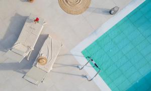 an overhead view of a swimming pool with two chairs and a table at Villa Oliva with Private Pool by Konnect in Kato Korakiana
