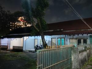 a house with a fence in front of it at night at Bale Sasak guest house in Selaparang
