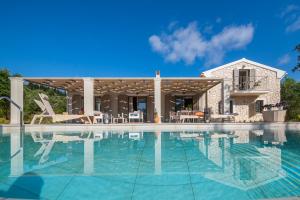 a swimming pool in front of a house at Villa Oliva with Private Pool by Konnect in Kato Korakiana