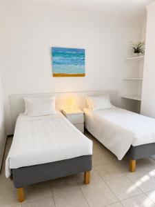 two beds sitting next to each other in a room at Apartamentos Central in Quarteira