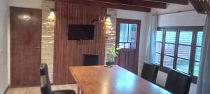 a dining room with a wooden table and chairs at Días y flores in Ranchos