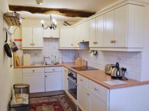 a kitchen with white cabinets and a counter top at Dewsnap Frost - Rb8 in Chinley