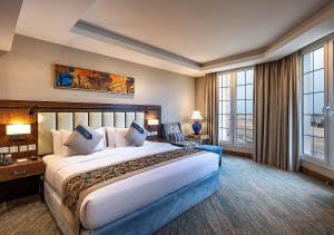 a hotel room with a large bed and large windows at Braiden Hotel in Al Jubail +96 photos