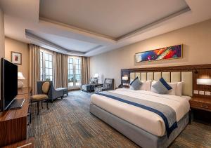 a hotel room with a large bed and a television at Braiden Hotel in Al Jubail