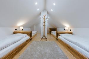 two beds in a room with white walls at Alpine HOUSE 77 in Kranjska Gora