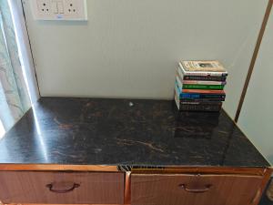 a counter top with a stack of books on it at Theprefabnest in Rishīkesh +17 photos