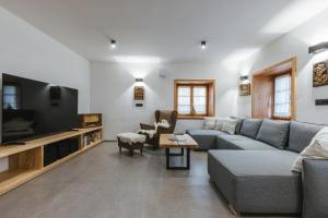 a living room with a couch and a tv at Alpine HOUSE 77 in Kranjska Gora