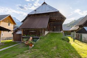 a large wooden building with a grass yard at Alpine HOUSE 77 in Kranjska Gora