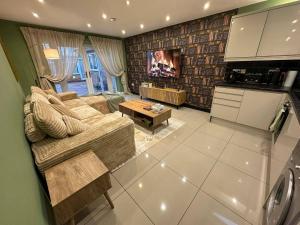 a living room with a couch and a kitchen at Stylish 2 Bed Flat Parking Sutton Coldfield in Birmingham