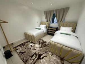 two beds in a room with a smashed floor at Stylish 2 Bed Flat Parking Sutton Coldfield in Birmingham