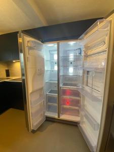 an empty refrigerator with its door open in a kitchen at Moderne 4-Zimmer Wohnung in Wernau