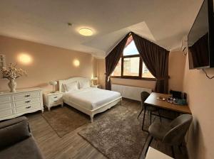 a bedroom with a bed and a desk and a window at Negru Voda 9- Old Town in Constanţa