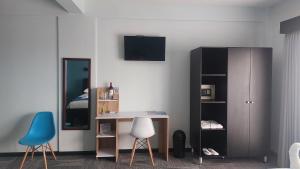 a bedroom with a desk and a bed and a mirror at Hotel Luckys in San Isidro de El General