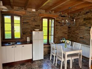 a kitchen with a table and a white refrigerator at Casa Venancio in Trabada