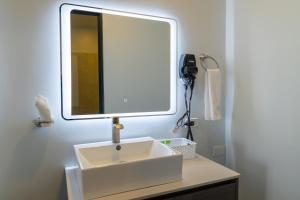 a bathroom with a white sink and a mirror at Hotel Luckys in San Isidro de El General
