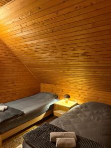 a room with two beds in a wooden cabin at Vila Rosa Kolasin in Kolašin