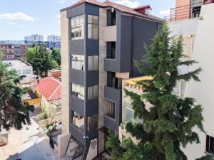 an apartment building with a tree in front of it at Numa Apart-Hotel in Tirana