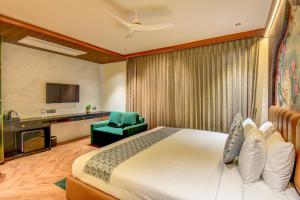 a hotel room with a bed and a chair at The White Castle Hotel in Mysore
