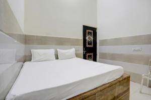 a bedroom with a large bed with white sheets at Hotel O The Starlight in Ghaziabad