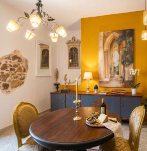 a dining room with a wooden table and chairs at Casa d'Artista con Terrazza Panoramica nel Borgo" Ajman house in Sambuca di Sicilia +6 photos