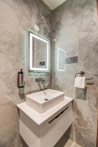 a bathroom with a white sink and a mirror at The White Castle Hotel in Mysore