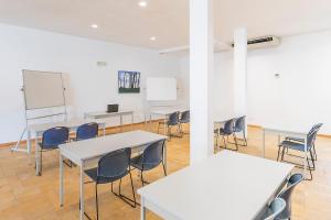 a classroom with tables and chairs and a white wall at HI Alcoutim – Pousada de Juventude in Alcoutim +71 photos
