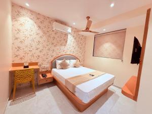 a bedroom with a bed and a desk and a television at Hotel Radhe Residency Taloja MIDC - Only accomodate Indian citizens in Panvel