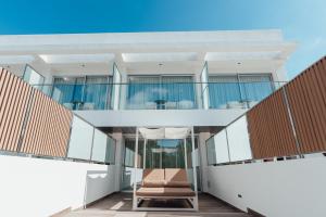 a house with a balcony with a chair at Petit Sagitario Adults only in Ciutadella