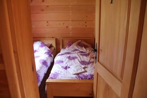 two beds in a small room with a door at BB Etno House in Kolašin