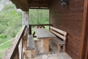 a wooden table and bench on the porch of a cabin at BB Etno House in Kolašin