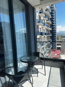 a table and chairs on a balcony with a view at Paradise Apartments Solis in Batumi