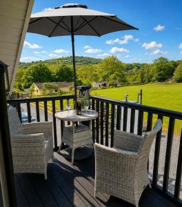 a table and chairs on a porch with an umbrella at The Loft in Gwys Station