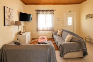 a living room with a couch and a tv at Villa Yannis 1 in Roda