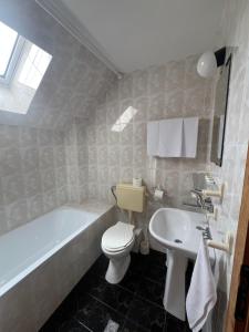 a bathroom with a tub and a toilet and a sink at Niko Hotel in Samokov +30 photos
