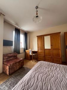 a bedroom with a bed and a chair and a desk at Niko Hotel in Samokov