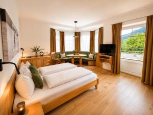 a bedroom with a bed and a living room at MÜHLBACHER - inklusive kostenfreiem Eintritt in die Alpentherme in Bad Hofgastein